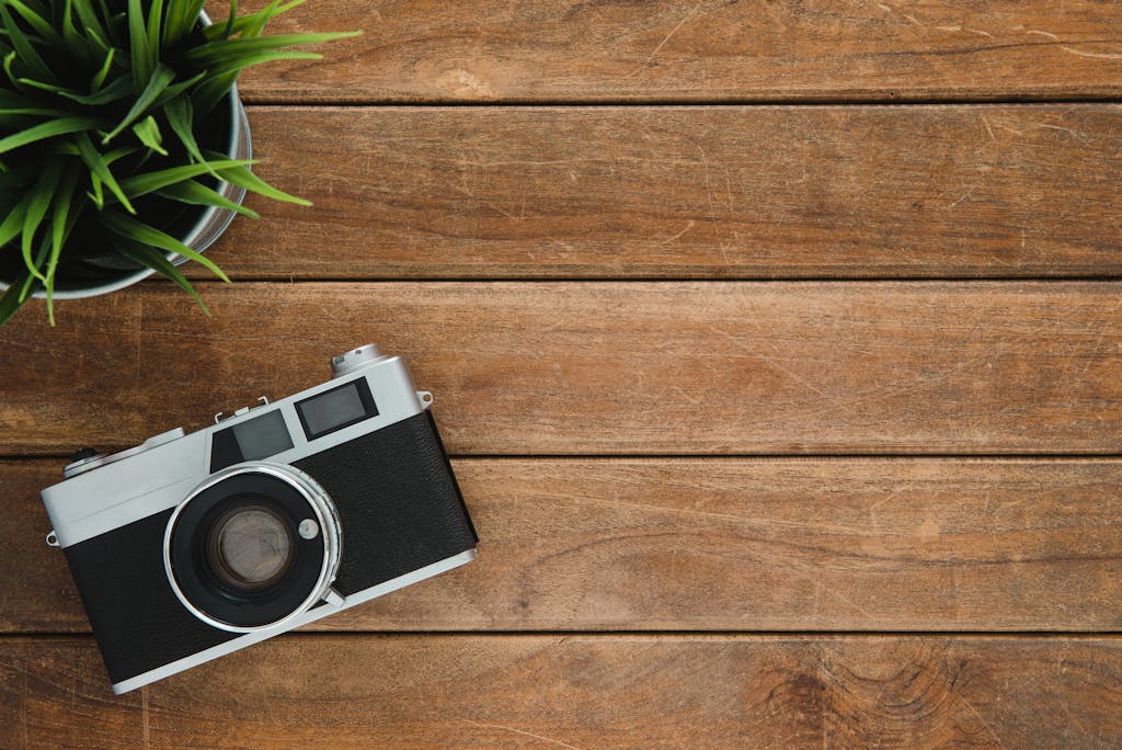 Black and Silver Film Camera on Brown Wooden Surface